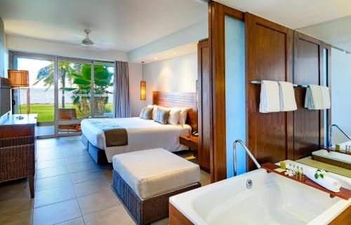 a hotel room with a bed and a bath tub at Hilton Fiji Beach Resort and Spa in Denarau