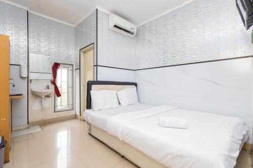 Postel nebo postele na pokoji v ubytování Alfa Guesthouse Serpong Mitra RedDoorz