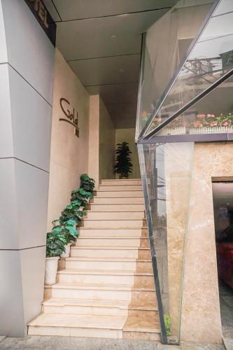 a staircase leading up to a building with potted plants at Gold Central Hotel by Haviland in Da Nang