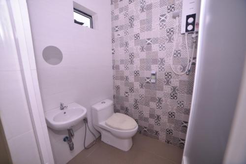 a small bathroom with a toilet and a sink at Bee Good Chalet in Yan