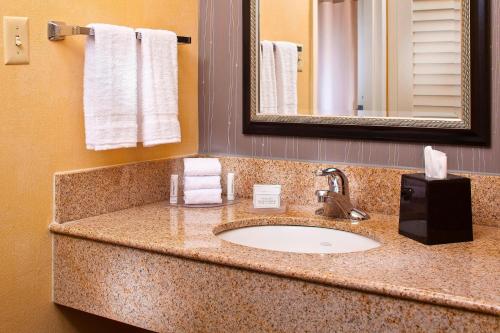 y baño con lavabo, espejo y toallas. en Courtyard by Marriott Huntsville University Drive en Huntsville