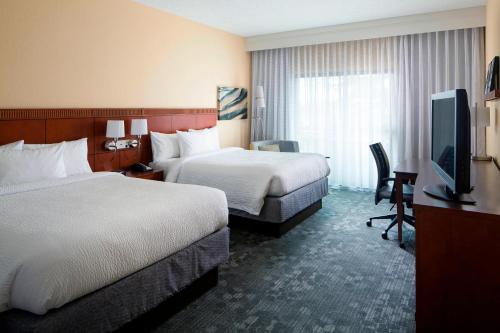 um quarto de hotel com duas camas e uma televisão de ecrã plano em Courtyard by Marriott Huntsville University Drive em Huntsville