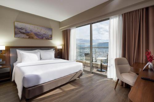 a hotel room with a bed and a large window at Annova Nha Trang Hotel in Nha Trang