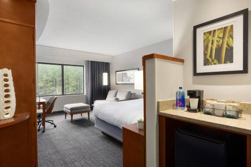 um quarto de hotel com uma cama e uma lareira em Courtyard Greenville em Greenville