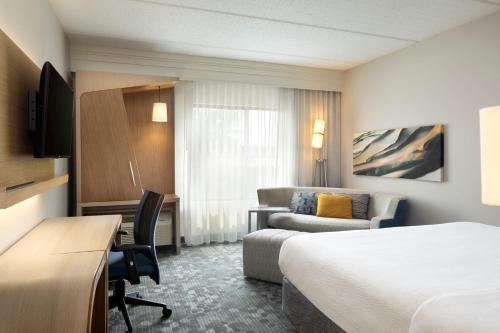 a hotel room with a bed and a desk at Courtyard by Marriott- Austin Round Rock in Round Rock