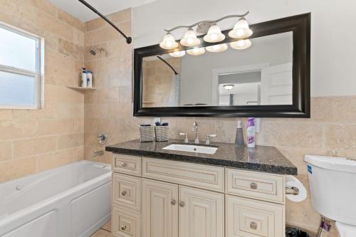 a bathroom with a sink and a tub and a mirror at LOVELY Ocean View Beach House 3BR Sleeps 9 in San Diego