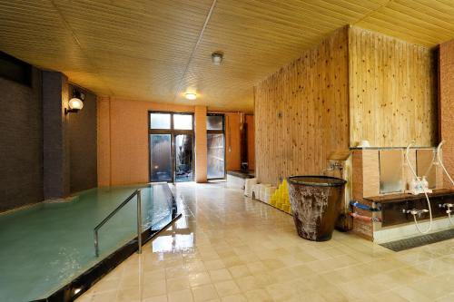 a large room with a swimming pool in a building at Tsubakikan in Aomori