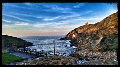 a view of the ocean with people in the water at APARTAMENTOS EL ROJU in Santillana del Mar