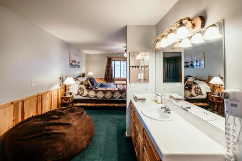 ein Badezimmer mit Waschbecken und großem Spiegel in der Unterkunft Alameda Landing- Pool Table- Hot Tub- Relaxing Log Cabin in Big Bear Lake