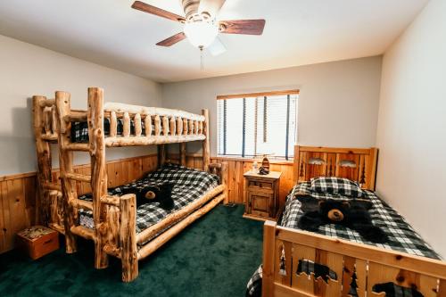 1 Schlafzimmer mit 2 Etagenbetten und einem Deckenventilator in der Unterkunft Alameda Landing- Pool Table- Hot Tub- Relaxing Log Cabin in Big Bear Lake