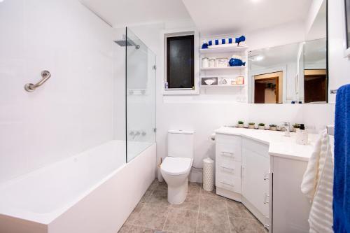 a white bathroom with a toilet and a shower at Snooty Fox Bed &Breakfast in Hazelbrook