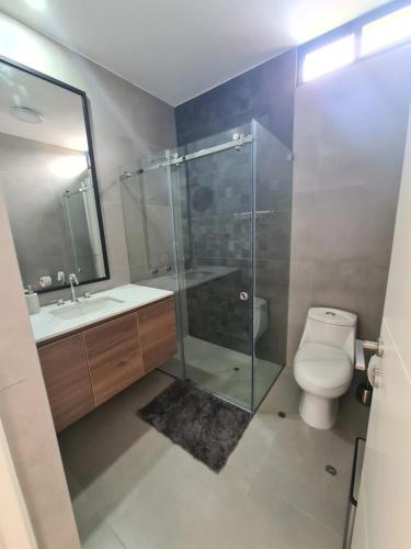 y baño con ducha de cristal y aseo. en Miraflores habitación separada con privacidad dentro de departamento compartido, en Lima