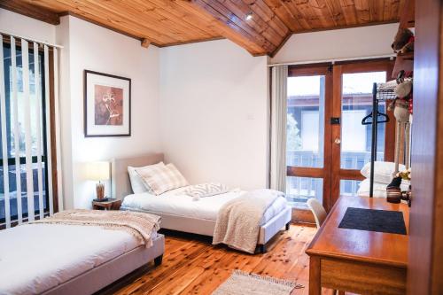 a bedroom with two beds and a desk and a table at Snooty Fox Bed &Breakfast in Hazelbrook