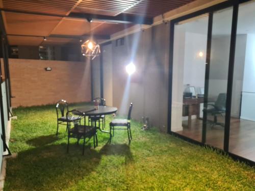 a patio with a table and chairs and grass at Miraflores habitación separada con privacidad dentro de departamento compartido in Lima