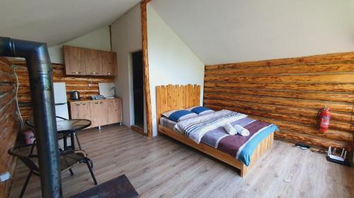 a bedroom with a bed and a wooden wall at Echoes of the mountains in Mestia