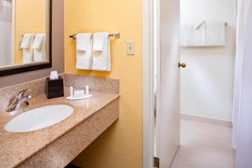 a bathroom with a sink and a mirror and towels at Courtyard Miami Airport West/Doral in Miami