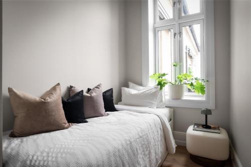 Un dormitorio con una cama blanca con almohadas y una ventana en Sophisticated apartment in Oslo en Oslo