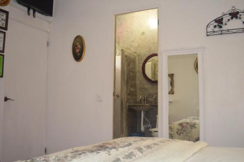 a bedroom with a bed and a mirror and a sink at Posada Casa Antigua in Tecolutla