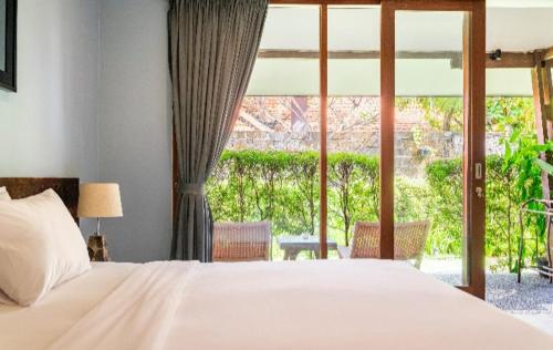 a bedroom with a bed and a large window at Big Brother Surf Inn in Canggu
