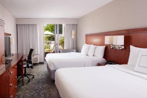 Habitación de hotel con 2 camas y escritorio en Courtyard Miami Coral Gables en Miami