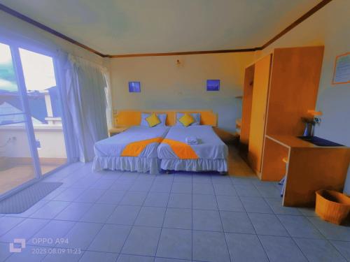 a bedroom with a bed with orange and white sheets at SM. Beach Side Place in Hua Hin