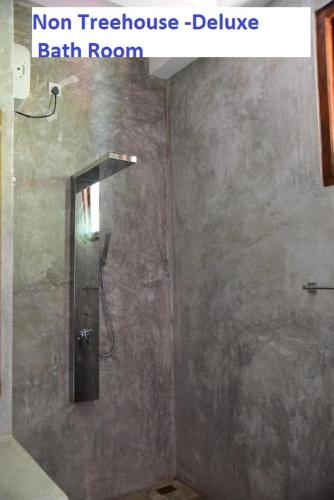 a shower stall in a bathroom with a shower door at Wilpattu Tree House in Wilpattu