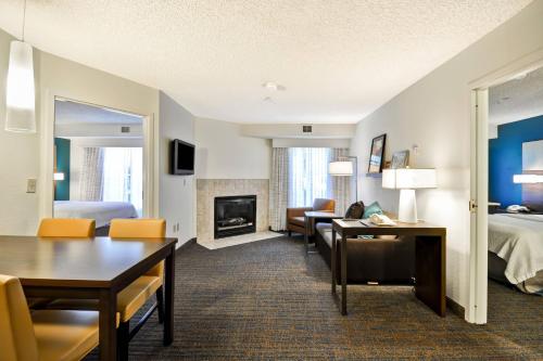 a hotel room with a bed and a living room at Residence Inn by Marriott Jacksonville Airport in Jacksonville