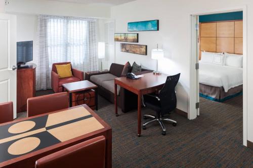 フェニックスにあるResidence Inn Phoenix North Happy Valleyのベッドとリビングルームが備わるホテルルームです。