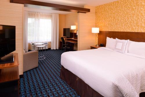 a hotel room with a bed and a flat screen tv at Fairfield Inn & Suites by Marriott Plymouth White Mountains in Plymouth