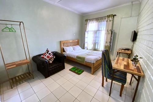 a bedroom with a bed and a chair and a table at TULIA LODGE in Eldoret