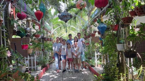 Eine Familie, die sich für ein Bild in einem Garten ausgibt. in der Unterkunft Canary Bungalow in Phu Quoc