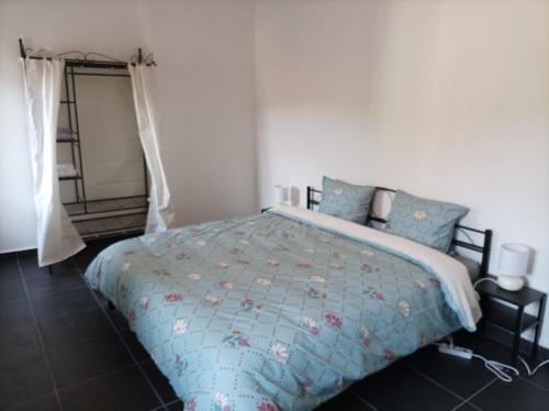 a bedroom with a bed with a blue comforter at O'Couvent - Appartement 441 - 3 chambres - 97 m2 - Quatrième étage in Salins-les-Bains