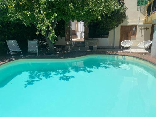 uma grande piscina com cadeiras num quintal em CANDIL SUITE Realejo em Granada