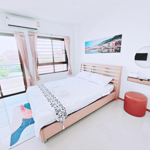 a bedroom with a bed and a television in it at Sugar Beach Bangsaen in Ban Bang Saen (1)