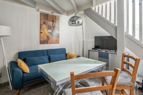 uma sala de estar com um sofá azul e uma mesa em Charming duplex near Paris - Welkeys em Boulogne-Billancourt