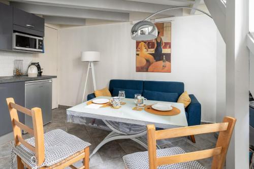 uma sala de estar com uma mesa e um sofá azul em Charming duplex near Paris - Welkeys em Boulogne-Billancourt