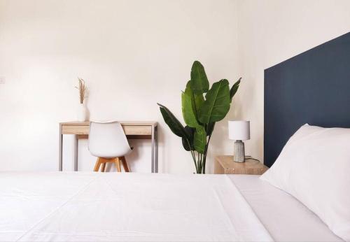 a bedroom with a white bed and a plant at La Maison d'Isa in Albion