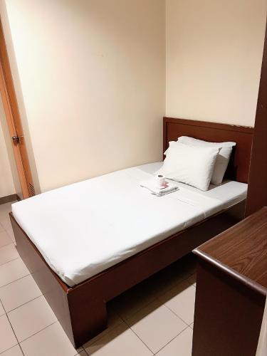 a bed in a room with a white mattress at Blue Velvet Hotel -CM Recto in Davao City