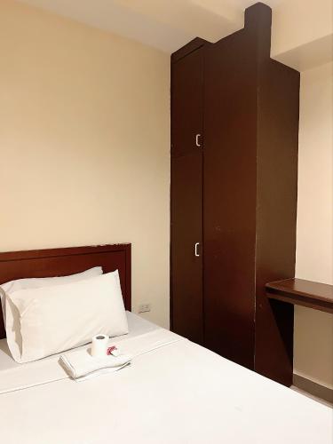 a bedroom with a bed with a book and a cupboard at Blue Velvet Hotel -CM Recto in Davao City