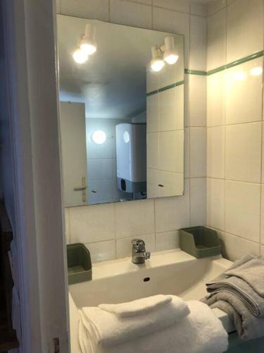 une salle de bain avec un lavabo, un miroir et des serviettes dans l'établissement Esprit cabine, à Versailles
