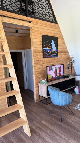 a room with a loft bed with a desk and a blue chair at Crna Ovca Lopatnica in Lopatnica