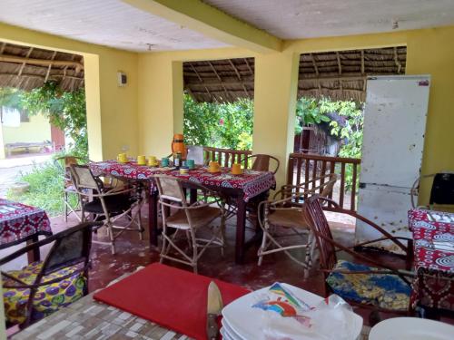 a dining room with a long table and chairs at Magharibi House in Nungwi