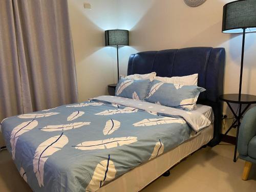 Seaview Sunset Accommodation في مدينة سيبو: غرفة نوم مع سرير مع اللوح الأمامي الأزرق