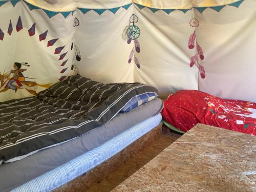 a bedroom with a bed in a tent at Tipis La Paix retrouvée in Tourrette-Levens
