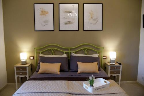 una camera con un letto con tre immagini appese al muro di SOLEMARE Rooms - CAMERA SUGHERO a Olbia