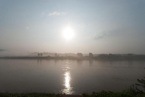 a river with the sun reflecting on the water at Namkhong Riverside in Chiang Khong