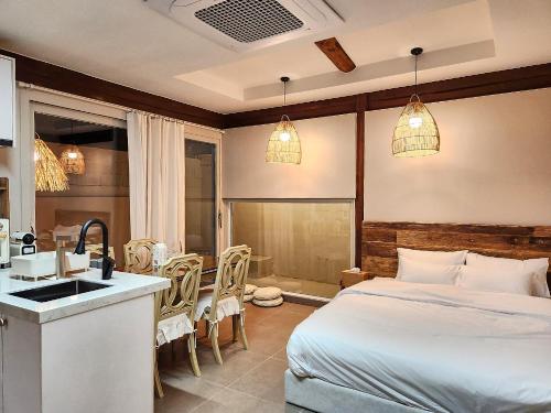 a bedroom with a bed and a kitchen with a sink at Relax House in Gyeongju