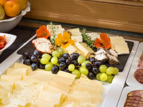 a plate of cheese and grapes and other foods at Aparthotel Gallahaus in Zell am Ziller