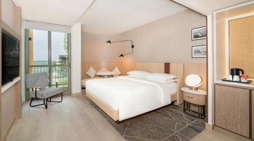 een slaapkamer met een wit bed en een balkon bij Sheraton Abu Dhabi Hotel & Resort in Abu Dhabi