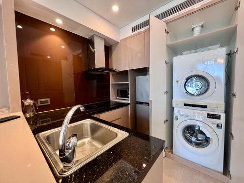 a kitchen with a sink and a washing machine at Luxury Apartment in Da Nang